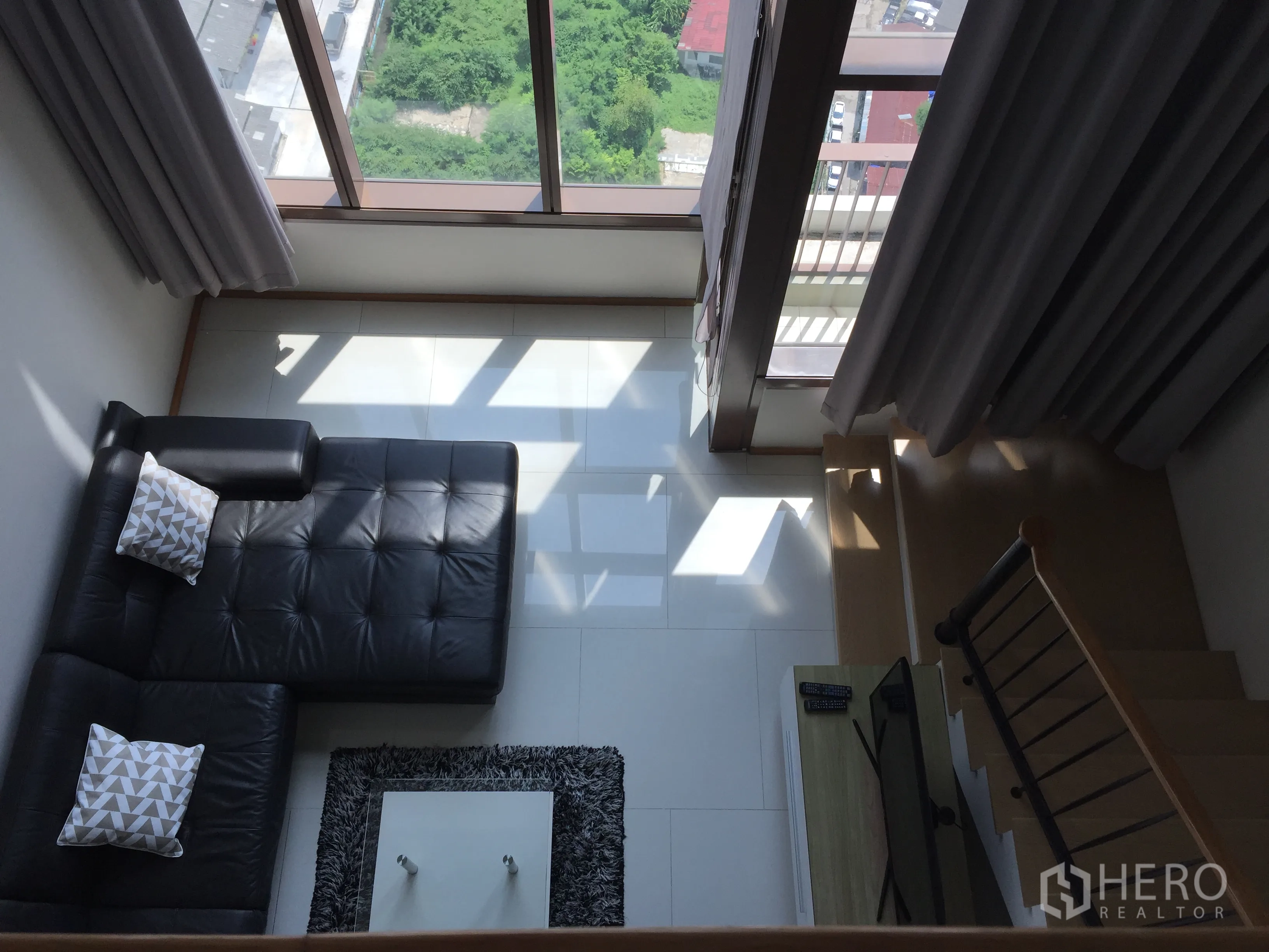 คอนโด ให้เช่าในKhlong Toei, Bangkok - ห้องนั่งเล่นเพดานสูง หน้าต่างเต็มผนัง โซฟาเข้ามุม และบันได