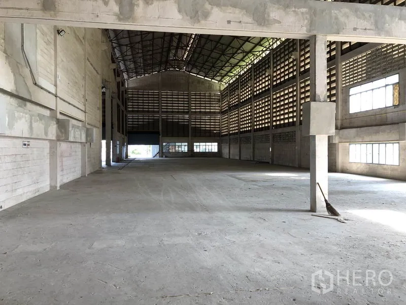 โรงงาน ให้เช่าในLam Luk Ka, Pathum Thani - ฮอลล์โกดังลึก พื้นคอนกรีต ผนังช่องลม และประตูม้วนด้านท้าย