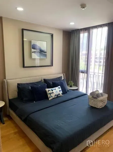 Condominium for rent or sale in Pathum Wan, Bangkok - Primary bedroom with large window, city view, dark bedding and soft lighting.