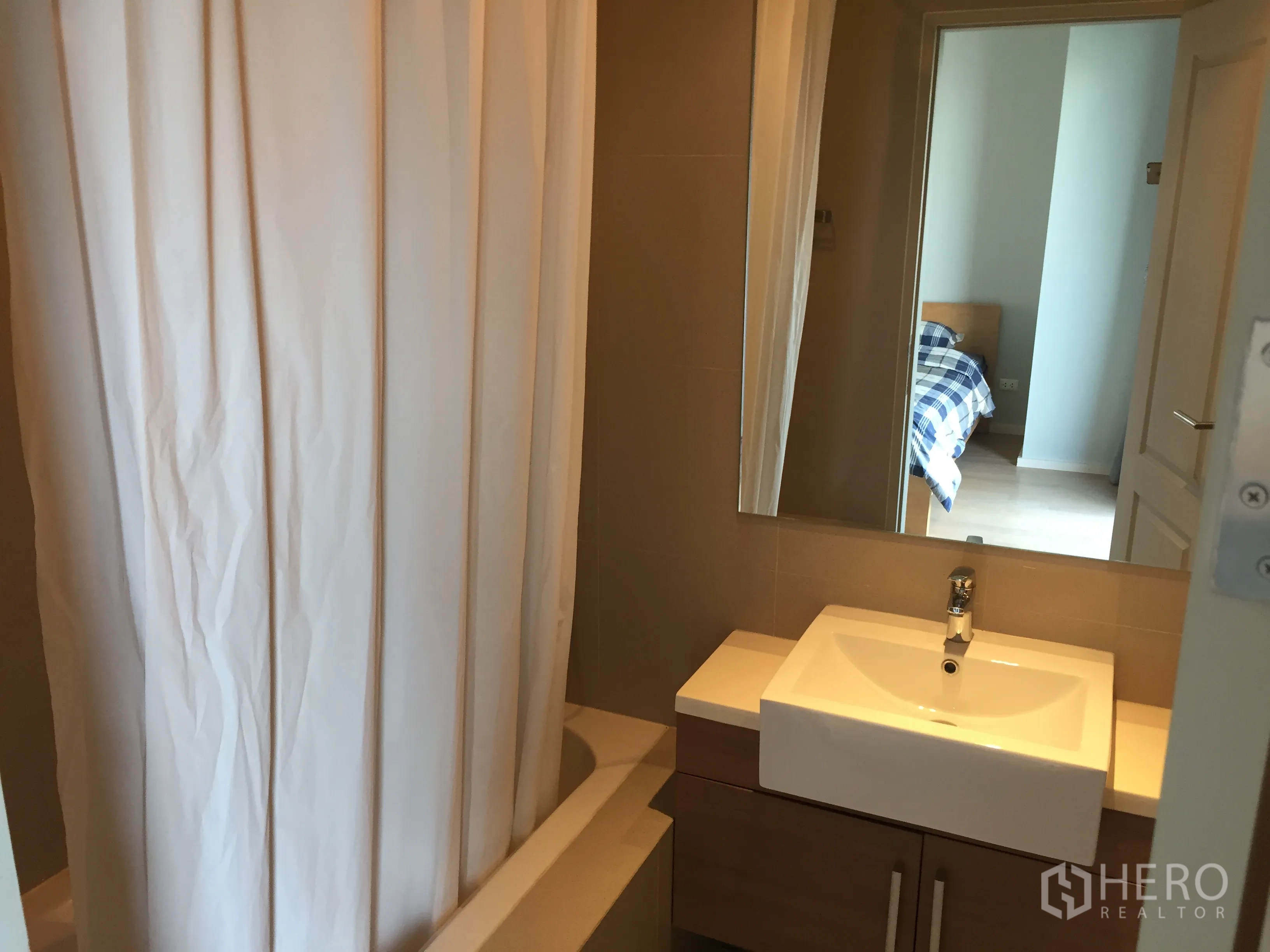 คอนโด ให้เช่าในBangkok - ห้องน้ำสมัยใหม่ พร้อมอ่างล้างหน้า กระจกบานใหญ่ และอ่างอาบน้ำพร้อมม่าน