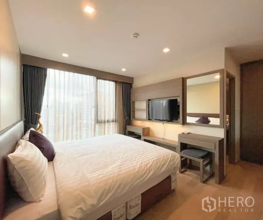 คอนโด ให้เช่า - ห้องนอนอบอุ่น ผ้าม่านสูงจรดเพดาน พร้อมทีวีและโต๊ะเครื่องแป้ง