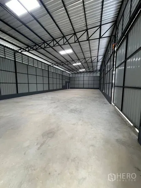 Warehouse for rent in Wang Thonglang, Bangkok - Spacious warehouse interior with high steel truss roof, skylights and smooth concrete floor in Wang Thonglang, Bangkok.