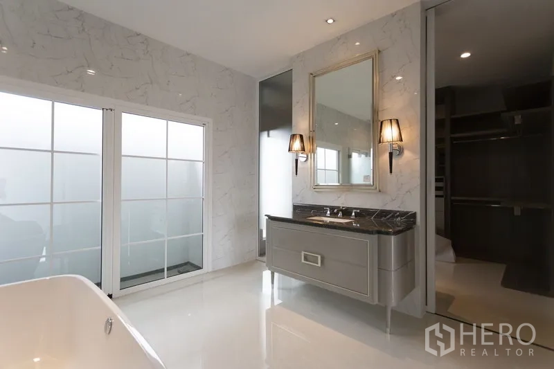 独立式住宅 出租在Mueang Samut Prakan, Samut Prakan - 豪华卫浴，仿大理石墙面、浴缸与双台盆，磨砂玻璃门。