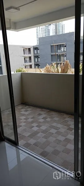 公寓 出租在Watthana, Bangkok - 私人阳台，铺设地砖，眺望周边建筑。
