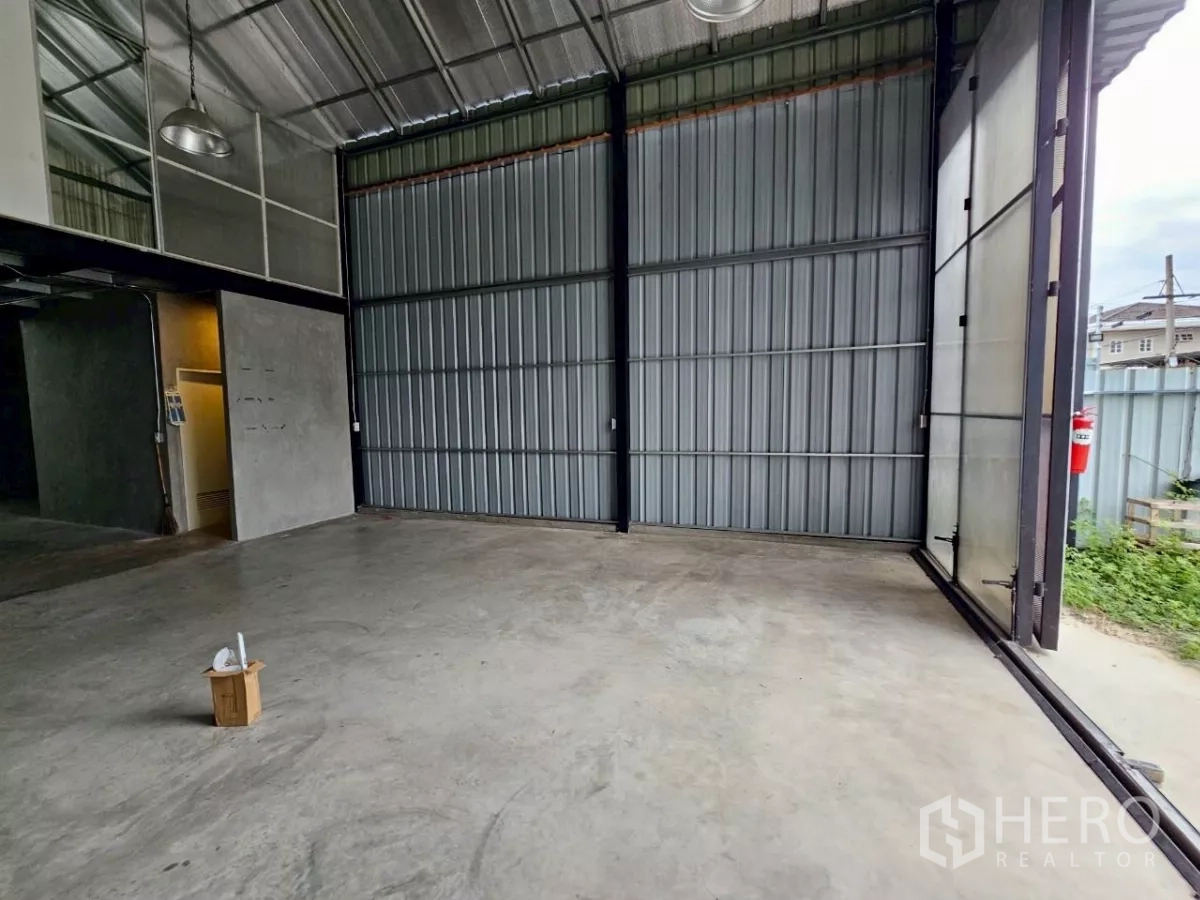 货栈 出租在Chatuchak, Bangkok - 一层仓储空间，混凝土地面与超高钢制推拉门。