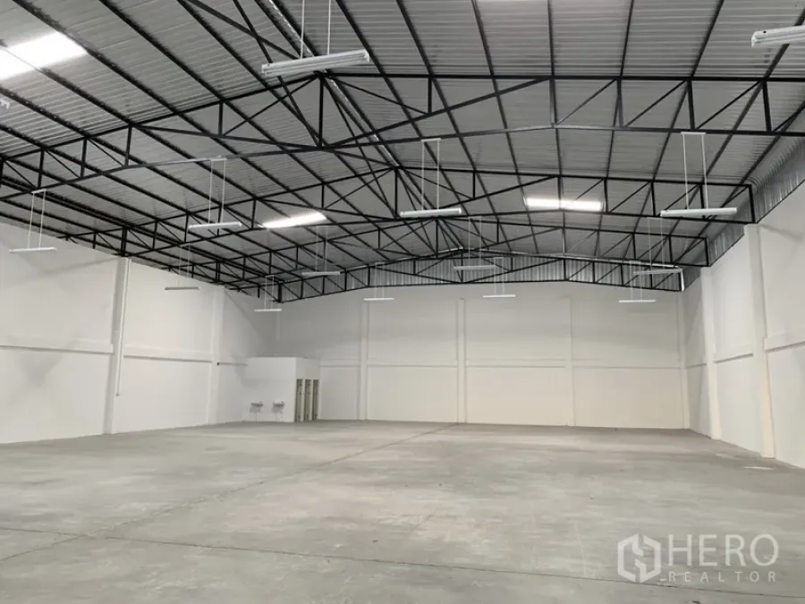 Warehouse for rent in Samut Prakan - Spacious warehouse interior in Bang Phli with high steel truss roof, bright LED lighting and polished concrete floor.