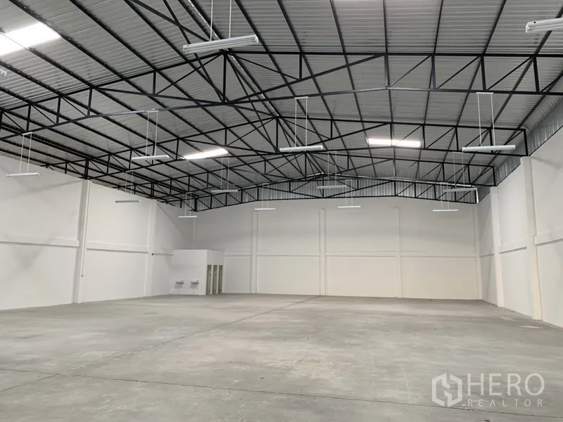 Warehouse for rent in Samut Prakan - Spacious warehouse interior in Bang Phli with high steel truss roof, bright LED lighting and polished concrete floor.