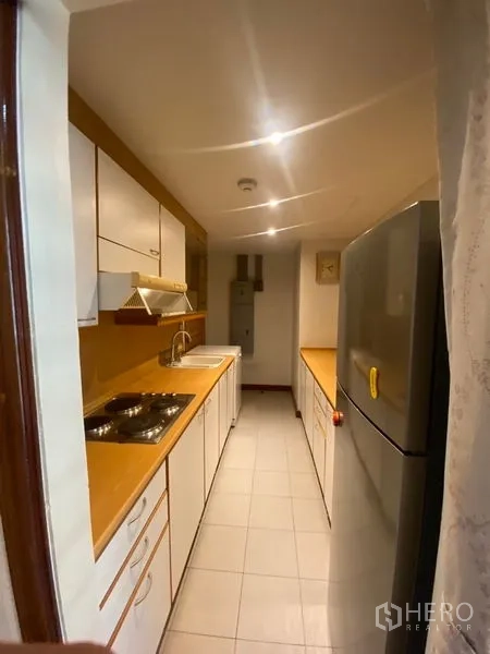 คอนโด ให้เช่าในPathum Wan, Bangkok - ครัวแยกแบบแกลเลอรี่ ตู้สีขาว เตา อ่างล้างจาน เครื่องดูดควัน และตู้เย็นขนาดใหญ่