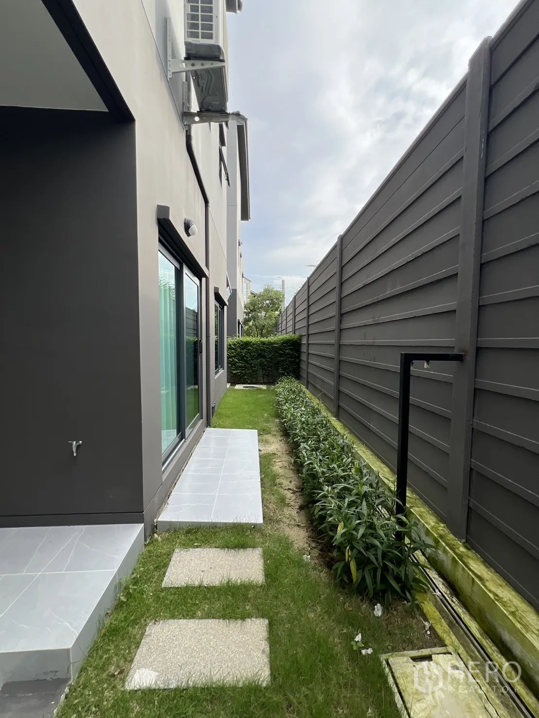 Detached House for rent in Prawet, Bangkok - Side garden with stepping stones and plants along privacy fence.