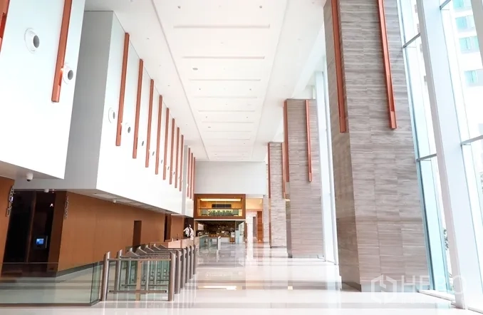 Office Space for rent in Khlong Toei, Bangkok - Grand office lobby with double-height ceiling, stone pillars, and security turnstiles.