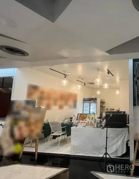 零售空间 出租在Watthana, Bangkok - 明亮的零售室内，白色天花、球形吊灯、轨道灯、服务台与咖啡馆式座位。