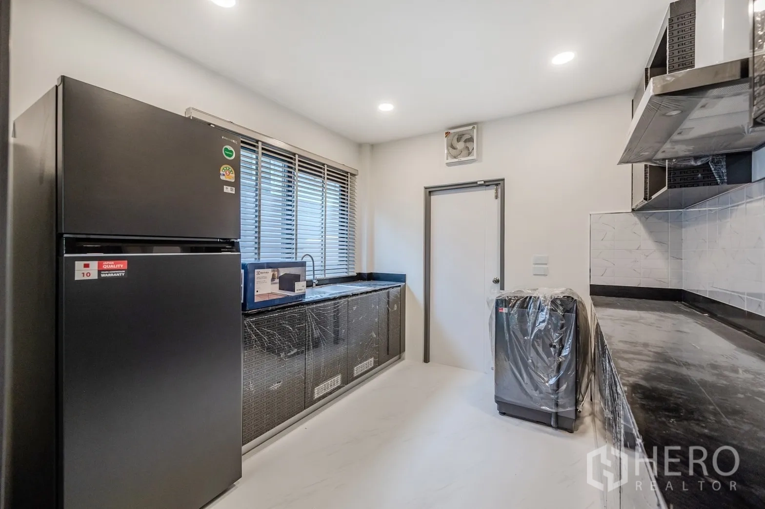 Detached House for rent in Bang Phli, Samut Prakan - Separate kitchen with black countertops, window, cabinets and appliances