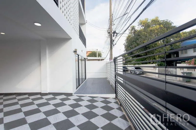 สำนักงานที่บ้าน ขายในHuai Khwang, Bangkok - ลานหน้าบ้านและทางรถเข้าพร้อมรั้วโลหะสีดำ พื้นกระเบื้องลวดลาย