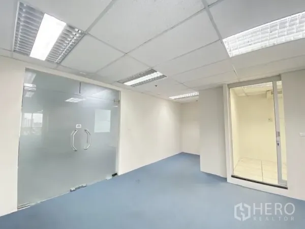 Office Space for rent in Chatuchak, Bangkok - Bright office room with drop ceiling lights, frosted glass double doors and blue carpet.