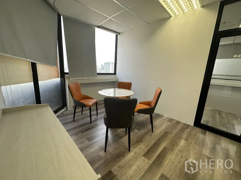 办公空间 出租或出售在Din Daeng, Bangkok - 小型洽谈角，圆形大理石桌与四把椅子，靠窗采光佳。