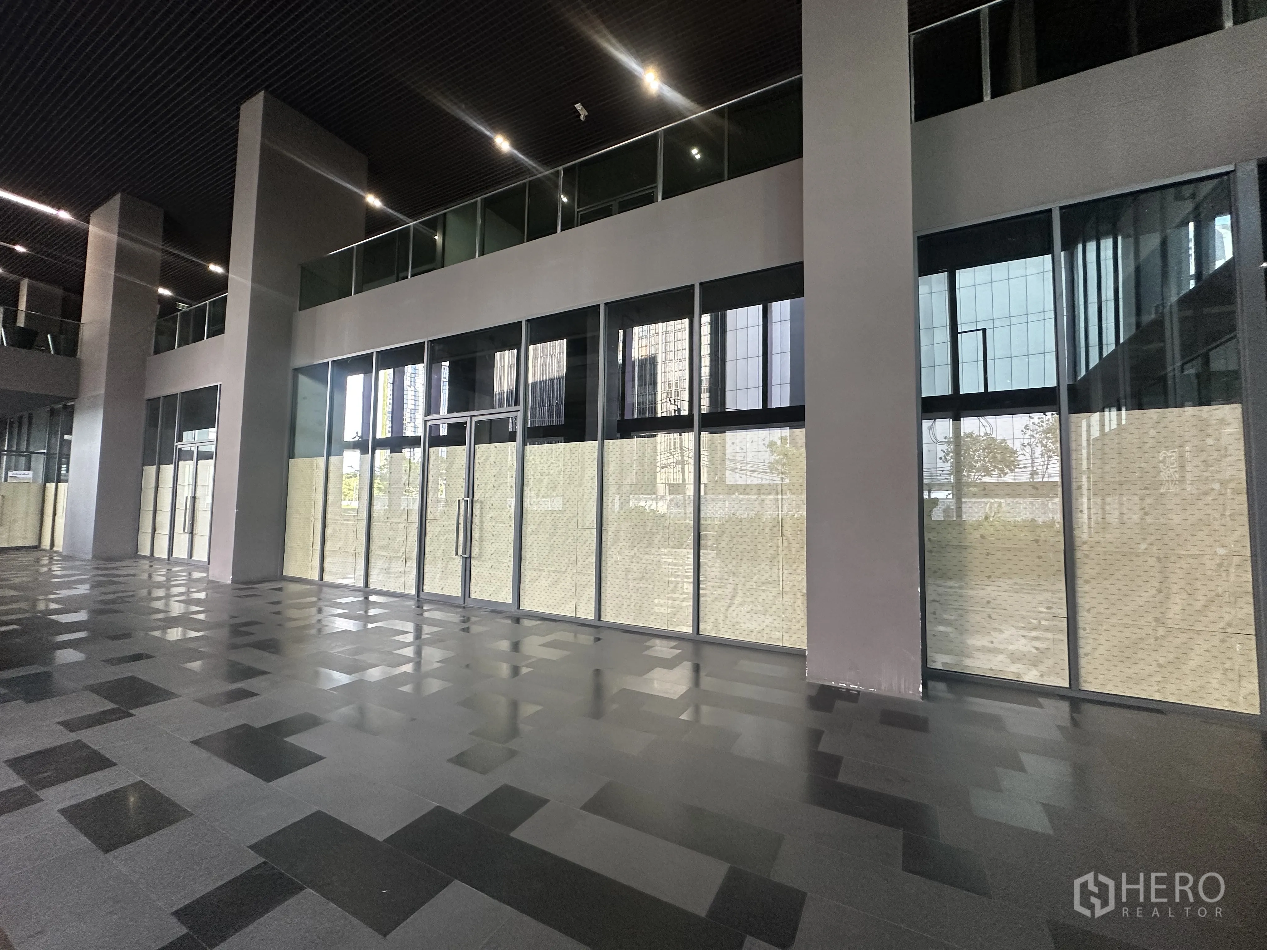 Retail Space for rent in Khlong Toei, Bangkok - Covered arcade with polished tile floor and expansive glass shopfronts.