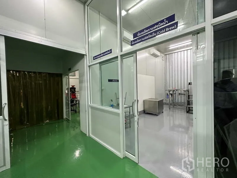 Factory for rent in Khlong Luang, Pathum Thani - Cleanroom entrance with sliding glass doors leading to a processing area with white insulated panels.