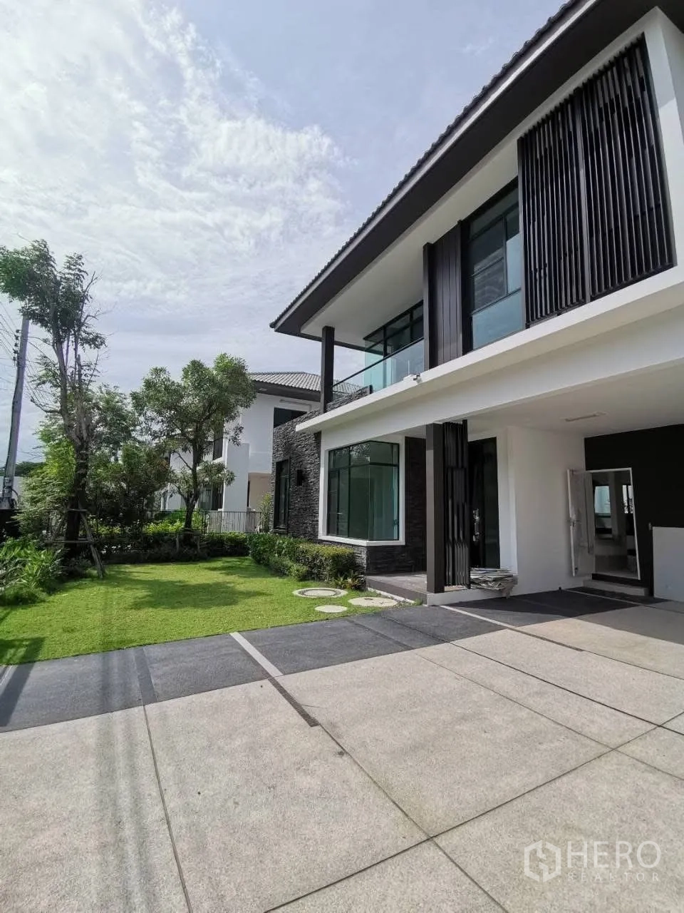 บ้านเดี่ยว for rent in Bang Phli, Samut Prakan - ด้านหน้าบ้านพร้อมลานจอดรถกว้าง สนามหญ้า และดีไซน์ร่วมสมัยสองชั้น