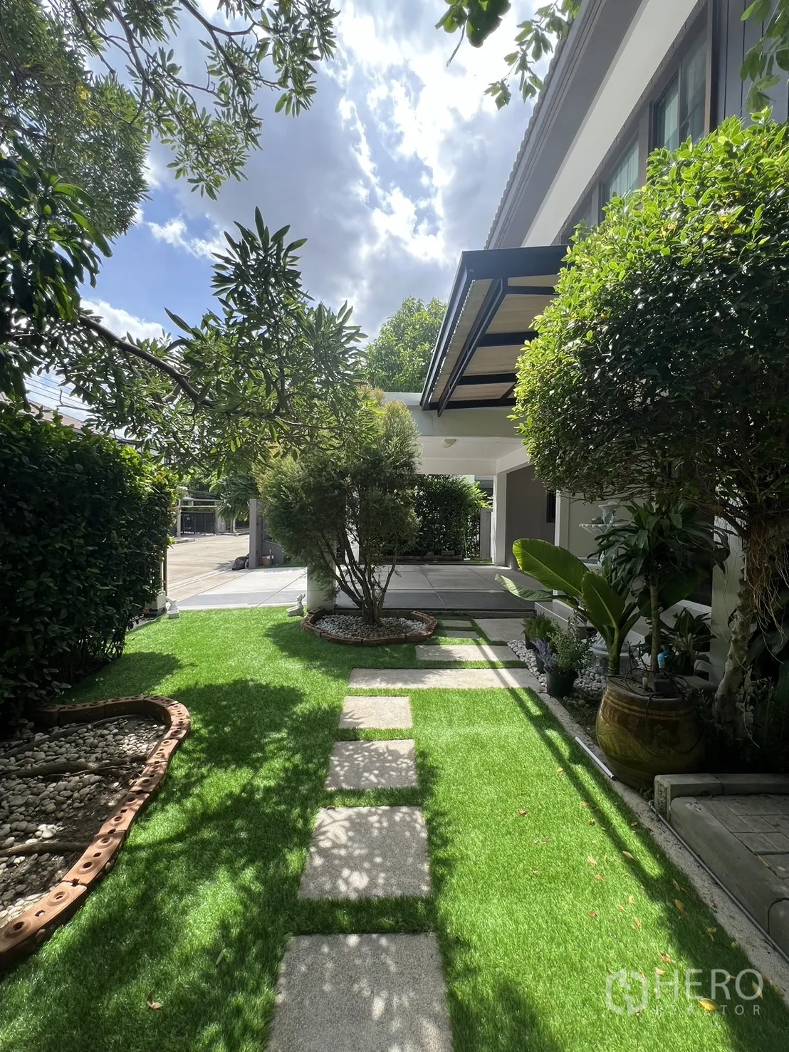 Detached House for rent in Bang Phli, Samut Prakan - Garden walkway leading to a covered porch framed by manicured shrubs.