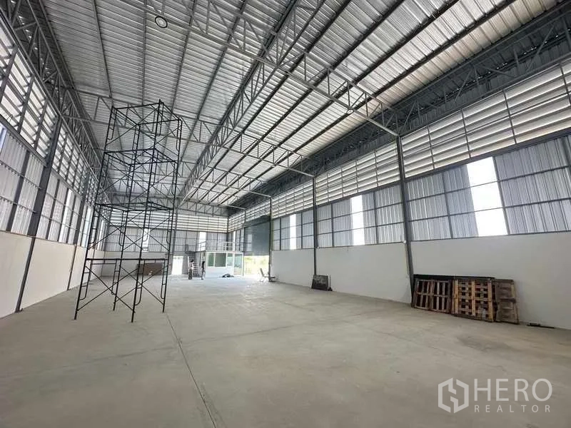 Warehouse for rent in Bang Bua Thong, Nonthaburi - Bright warehouse hall with ventilation louvers, tall roof and roller door.