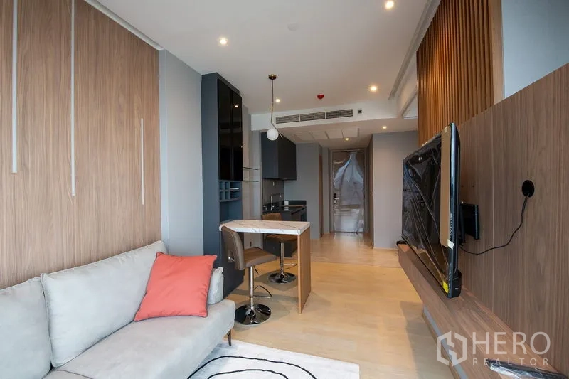 公寓 出租在Din Daeng, Bangkok - 从客厅望向玄关的长景，挂墙电视、浅色木地板与筒灯照明。
