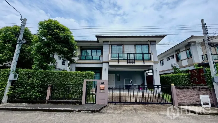 独立式住宅 出租或出售在Bang Phli, Samut Prakan - 两层独栋别墅正立面，带大门车道与修剪整齐的绿篱，位于邦普里。