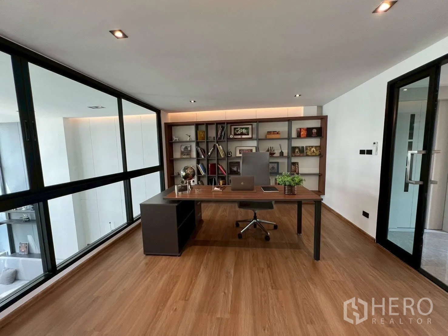 Home Office for rent or sale in Mueang Samut Prakan, Samut Prakan - Private executive office with desk, chair and built-in bookshelf behind glass walls.