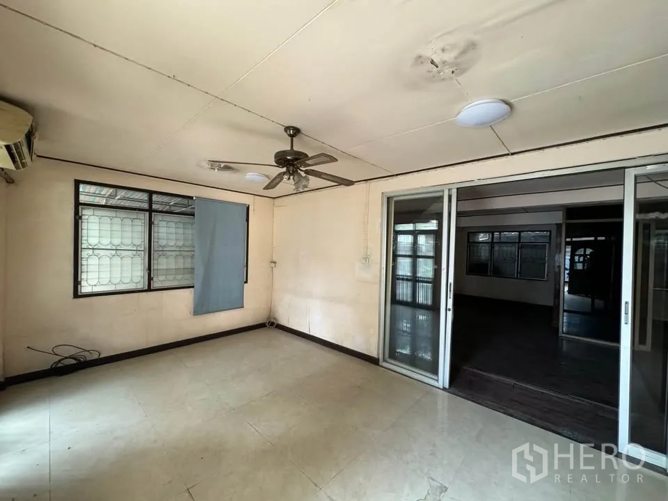 Detached House for rent or sale in Watthana, Bangkok - Bright multipurpose room with sliding glass doors and tiled flooring.