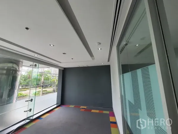 Office Space for rent in Watthana, Bangkok - Small office by full-height windows with greenery views and a glass door.
