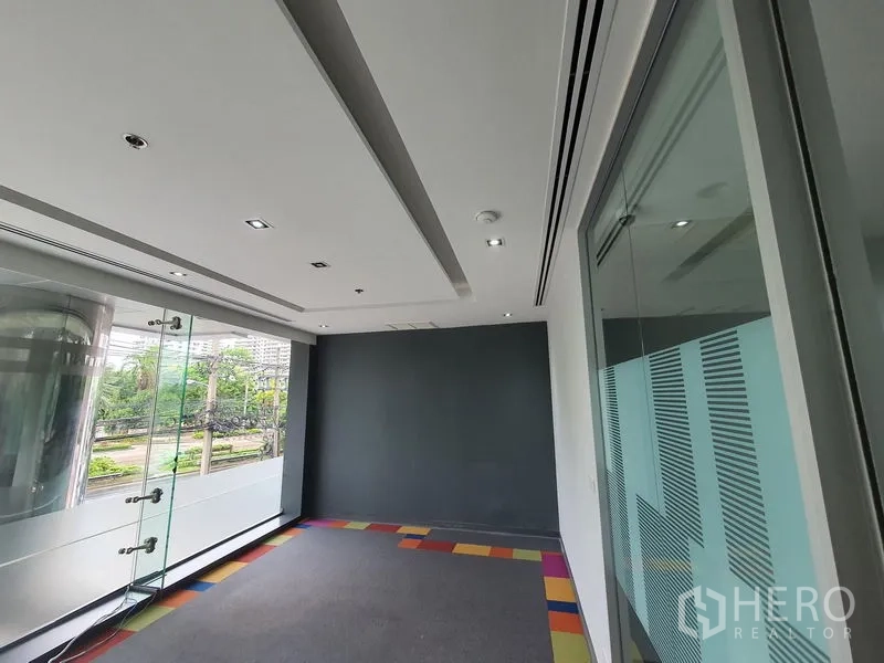 Office Space for rent in Watthana, Bangkok - Small office by full-height windows with greenery views and a glass door.