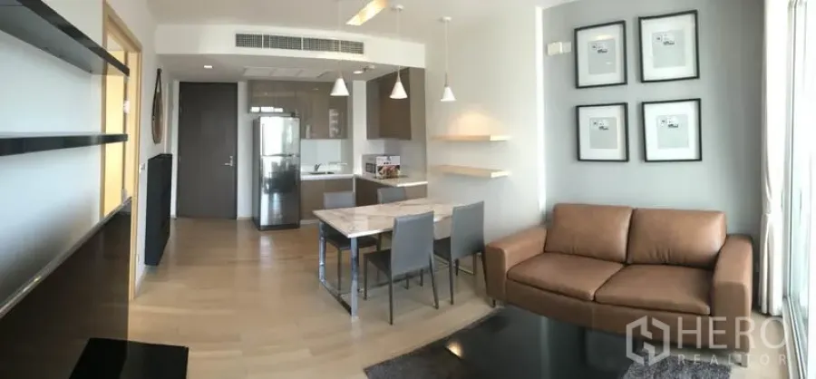 คอนโด ให้เช่าในKhlong Toei, Bangkok - มุมมองกว้างของพื้นที่ใช้สอย เห็นครัว ชุดทานอาหาร และโซฟาพร้อมพื้นไม้ที่ Siri at Sukhumvit