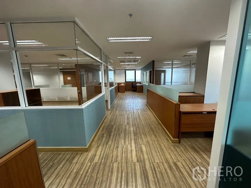 Office Space for rent or sale - Office corridor with frosted-glass partitions leading to windowed area.
