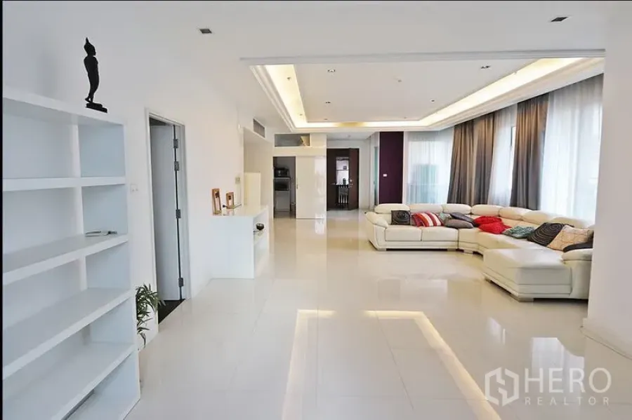 คอนโด ให้เช่าในWatthana, Bangkok - ห้องนั่งเล่นแบบโอเพ่นสเปซกว้างขวาง โซฟาเข้ามุมสีขาว ไฟซ่อนฝ้า พื้นกระเบื้องเงา และหน้าต่างบานใหญ่พร้อมผ้าม่าน