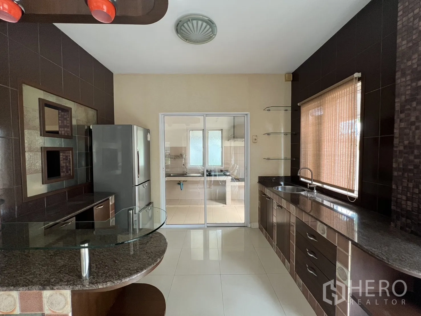 บ้าน ให้เช่าในLat Krabang, Bangkok - ครัวสไตล์ตะวันตก เคาน์เตอร์หินแกรนิต ตู้เย็น และประตูบานเลื่อนไปครัวไทย