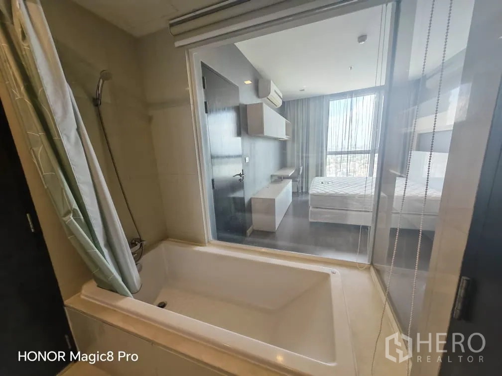 คอนโด for rent in Watthana, Bangkok - ห้องน้ำมีอ่างอาบน้ำพร้อมฝักบัวและฉากกระจกมองเห็นห้องนอน