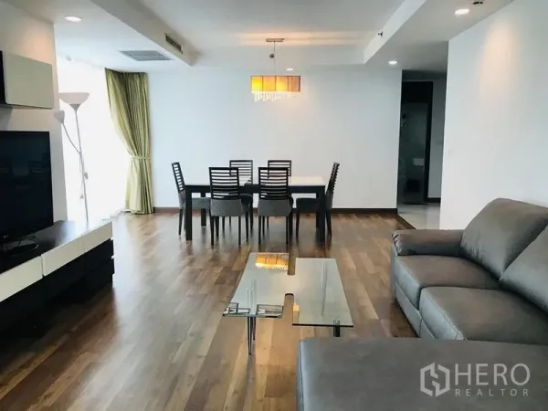 คอนโด ให้เช่าในPathum Wan, Bangkok - ห้องนั่งเล่นเชื่อมส่วนรับประทานอาหาร โซฟา โต๊ะกระจก โคมไฟแขวน และหน้าต่างบานใหญ่