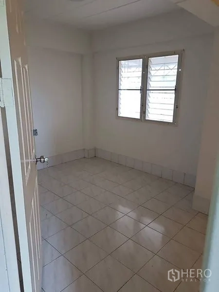 Retail Space for sale in Lam Luk Ka, Pathum Thani - Small bright room with window security bars and white tile flooring.