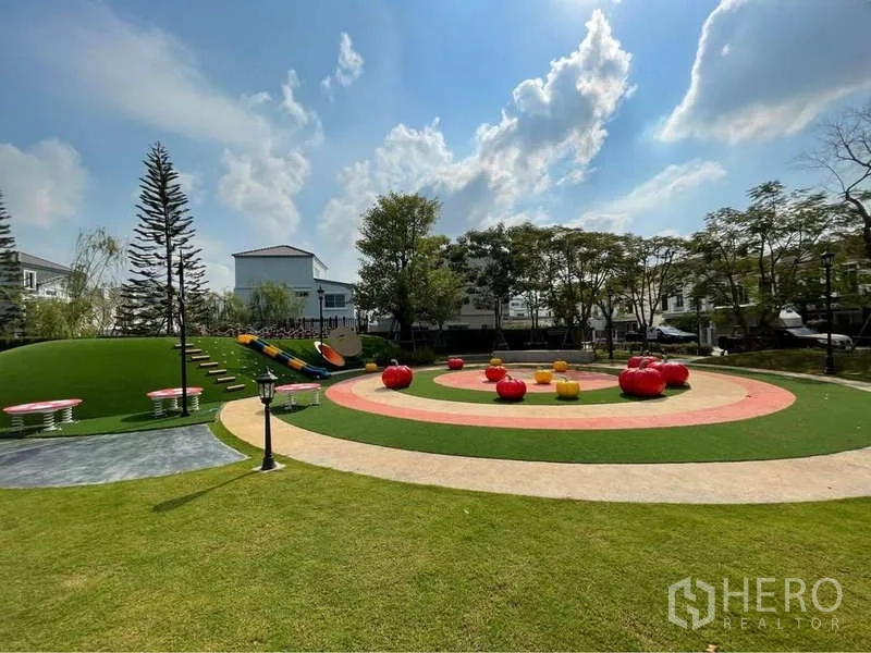 Detached House for rent in Prawet, Bangkok - Colorful community playground on a green lawn with slides and seating mounds.