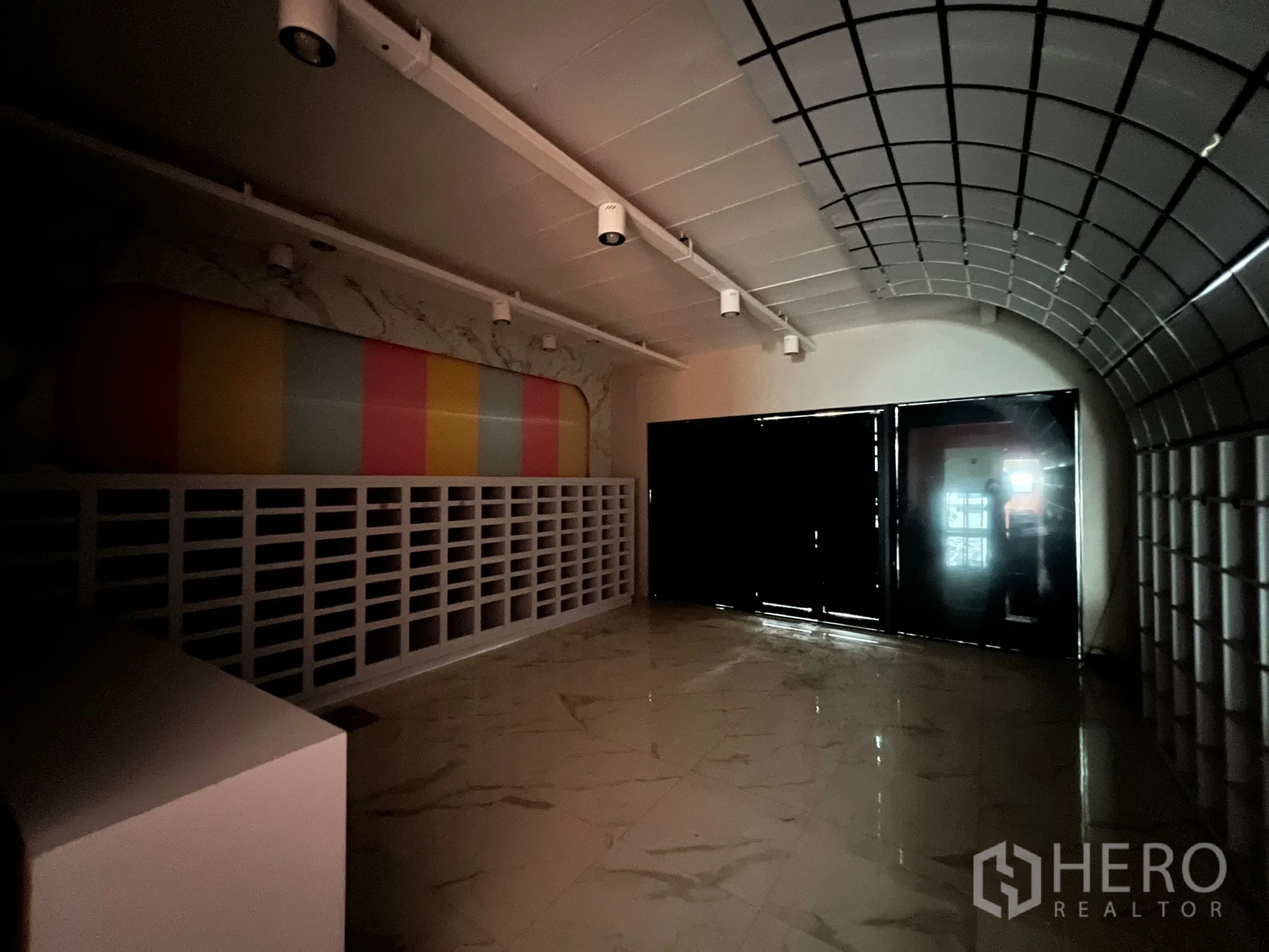 店屋 出租在Watthana, Bangkok - 昏暗展示区，拱形网格天花、亮面地坪与彩色装饰墙。