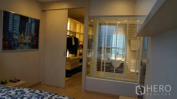 คอนโด ให้เช่าในWatthana, Bangkok - มุมห้องนอนไปยังห้องแต่งตัวประตูบานเลื่อน และห้องน้ำกั้นกระจกในโทนไม้อบอุ่น