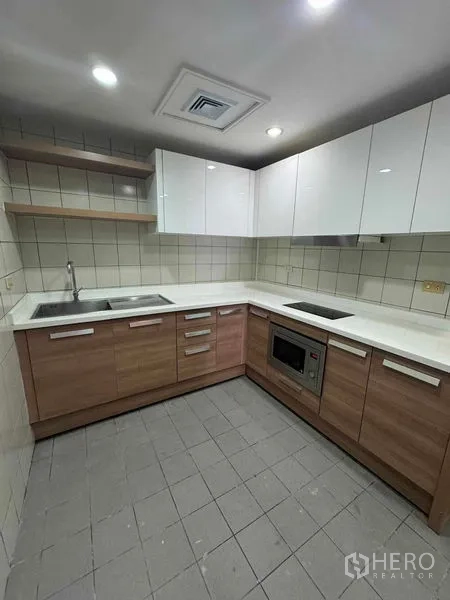 คอนโด ให้เช่าในPathum Wan, Bangkok - ครัวรูปตัว U ตู้บนสีขาว ตู้ล่างลายไม้ และเครื่องใช้บิวท์อิน