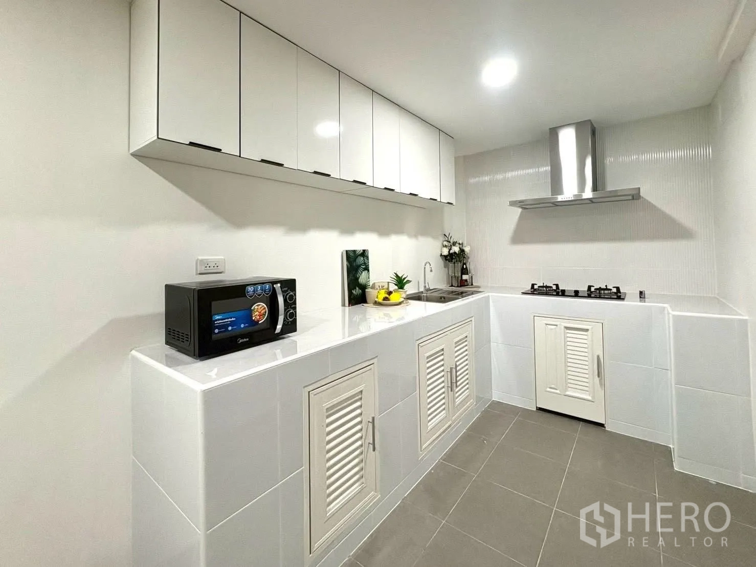 联排别墅 for rent in Huai Khwang, Bangkok - 纯白厨房，吊柜与地柜、水槽、微波炉和燃气灶加烟机。