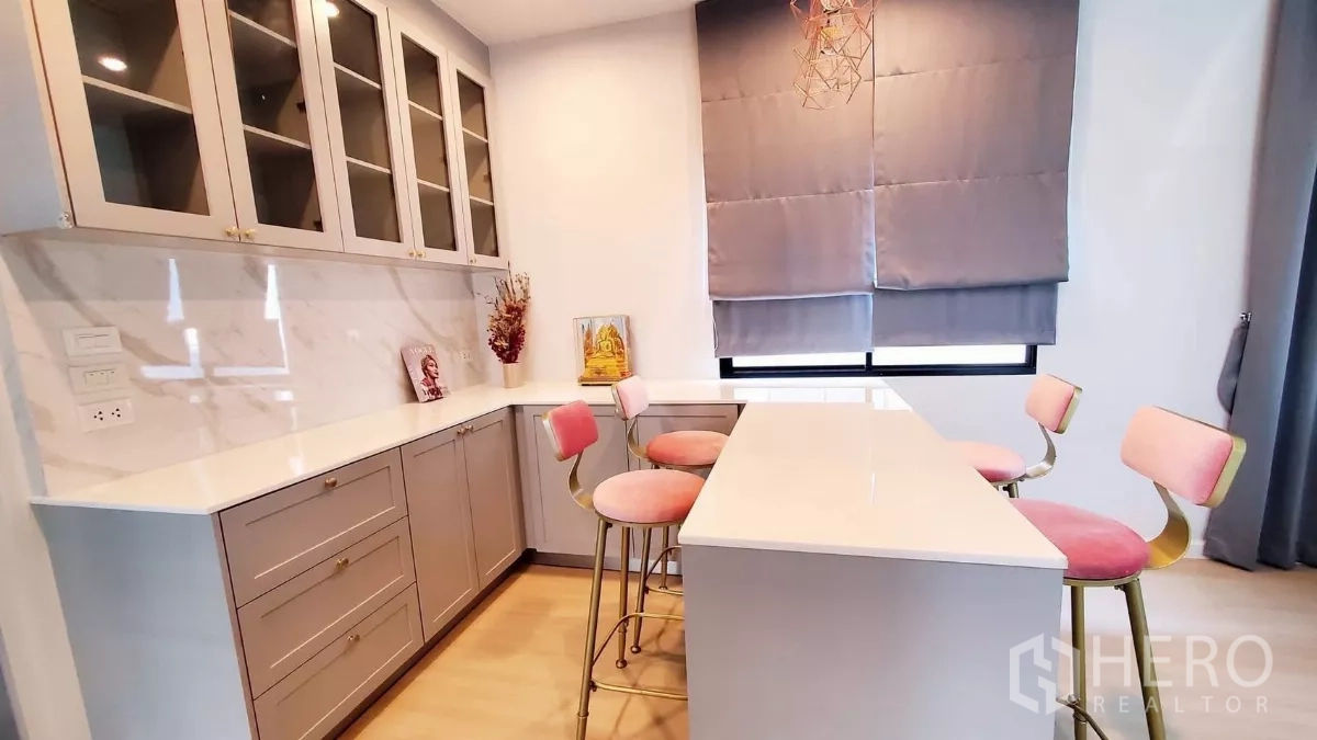บ้าน ให้เช่าในLat Krabang, Bangkok - แพนทรี่ท็อปหินสีขาว ตู้กระจกบน เกาะกลาง พร้อมสตูลสีชมพูและไฟบรรยากาศ