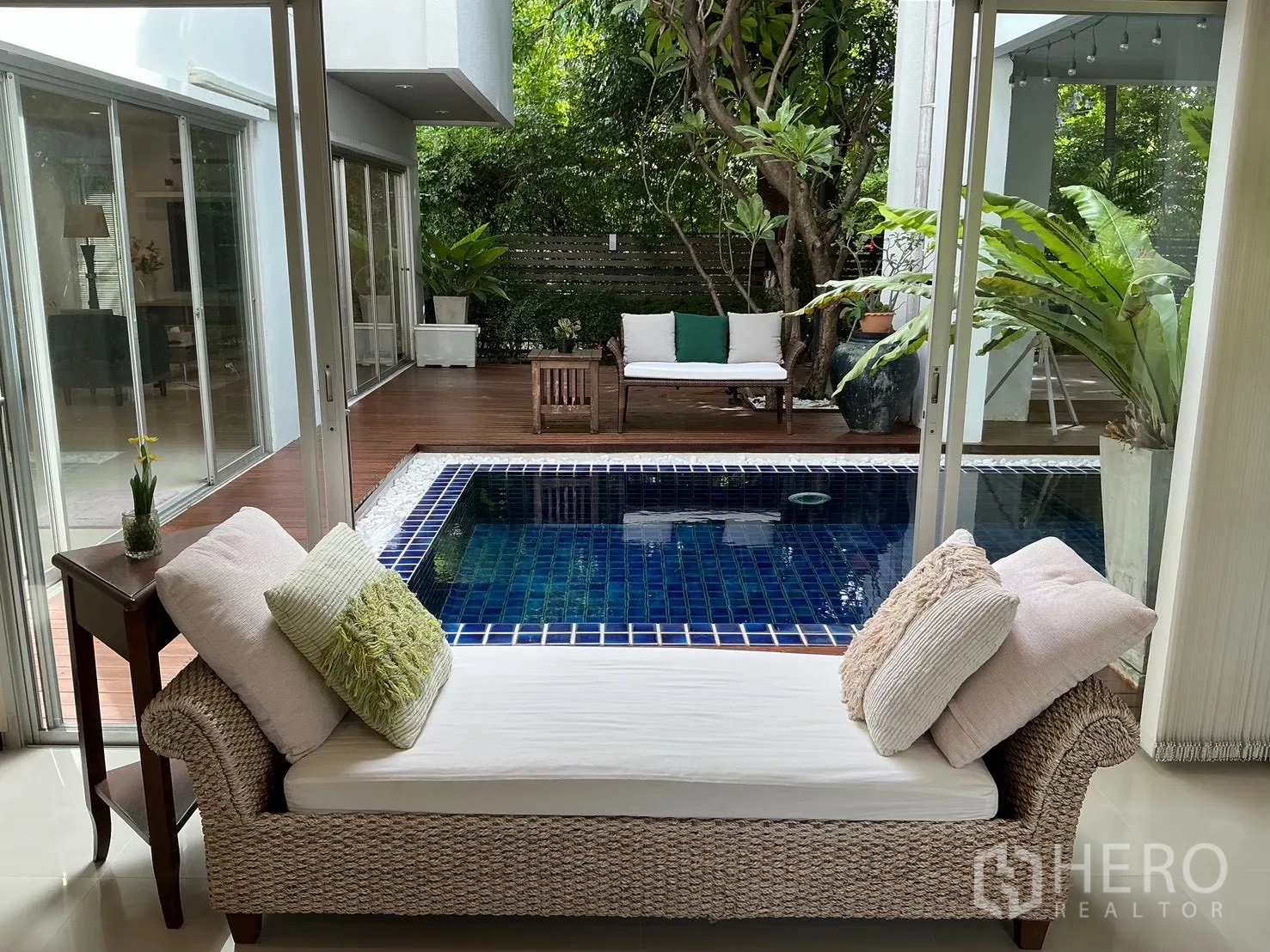 บ้านเดี่ยว for sale in Suan Luang, Bangkok - เลานจ์ในบ้านมองเห็นสระว่ายน้ำกระเบื้องสีน้ำเงินและดาดไม้
