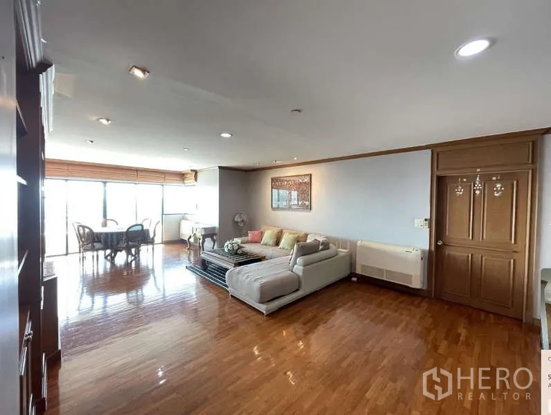 คอนโด ให้เช่า - พื้นที่นั่งเล่นและทานอาหารแบบโอเพ่นแปลน พร้อมโซฟาและประตูบานเลื่อนออกระเบียง