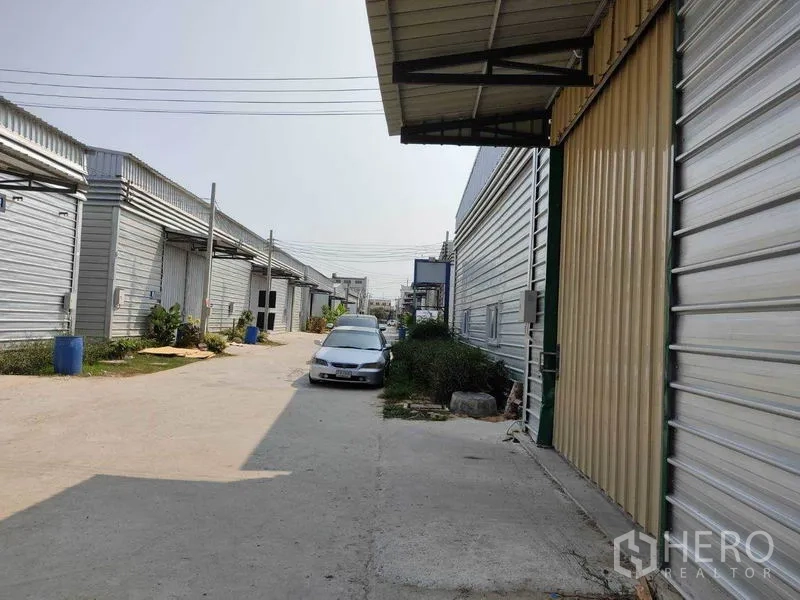 Warehouse for rent in Bang Phli, Samut Prakan - Compound driveway lined with warehouses, suitable for car and truck movement.
