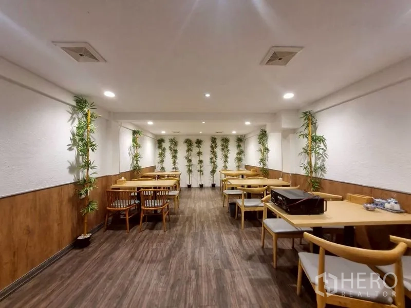 店屋 出租或出售在Watthana, Bangkok - 楼上用餐室，木地板与盆栽竹子装饰。