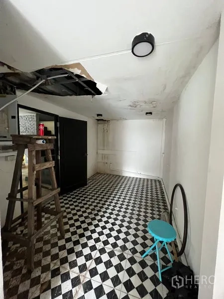 店屋 出租在Watthana, Bangkok - 后场房间，黑白棋盘地砖，天花部分需维修。