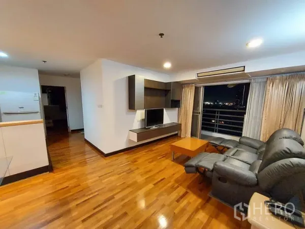 公寓 出租或出售在Khlong Toei, Bangkok - 客厅配电动躺椅，电视柜与推拉门通往阳台夜景