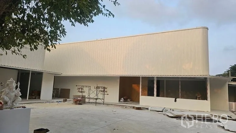 สำนักงาน ให้เช่าในBang Phli, Samut Prakan - อาคารสำนักงานสีขาวกำลังปรับปรุง มีนั่งร้านและทางเข้า–ลานจอดรถกว้างด้านหน้า